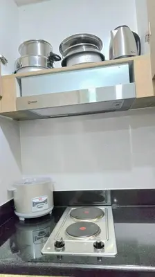 a kitchen with a stove with pots and pans at Shore 2 Tower 3 Condo near MOA by Dei Gratia in Manila