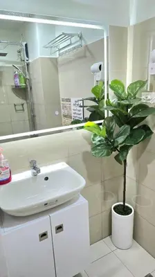 a bathroom with a sink and a potted plant at Shore 2 Tower 3 Condo near MOA by Dei Gratia in Manila