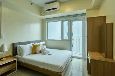 a small bedroom with a bed and a window at The Suite Life - Level 42 at Makati in Manila