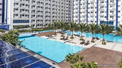 an overhead view of a swimming pool with palm trees and a building at The Suite Life - Level 42 at Makati in Manila
