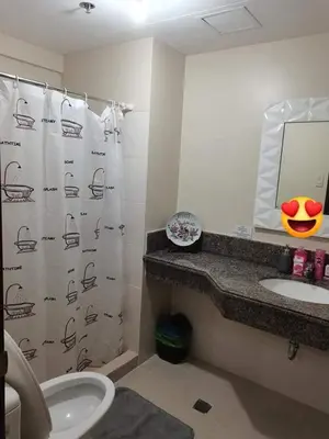 a bathroom with a shower curtain and a sink at 3BR Condo Unit at Mirea Residences in Manila