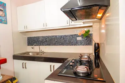 a small kitchen with a stove and a sink at Calm House near Enchanted Kingdom Sta Rosa with Free Parking, Wifi, Netflix in Santa Rosa