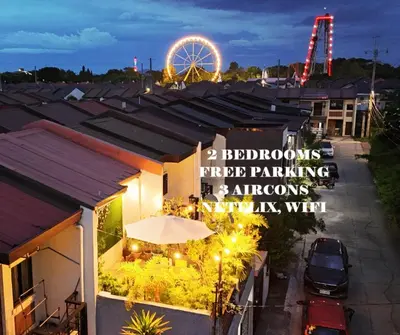 a building with a ferris wheel in the background at Calm House near Enchanted Kingdom Sta Rosa with Free Parking, Wifi, Netflix in Santa Rosa