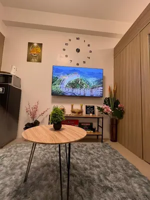 a living room with a table and a clock on the wall at SHORE 2 Residences MOA in Manila