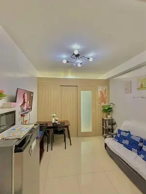 a living room with a bed and a dining room at SHORE 2 Residences MOA in Manila