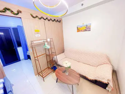 a small bedroom with a bed and a table at SHORE 2 Residences MOA in Manila