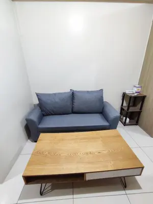 a blue couch in a room with a coffee table at Breeze Residences Manila in Manila