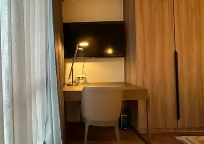 a room with a desk with a chair and a lamp at The Hotel at Tower Acqua 1 in Manila
