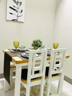 a dining room table with two white chairs around it at Taguig Parksuit 1BGC in Manila