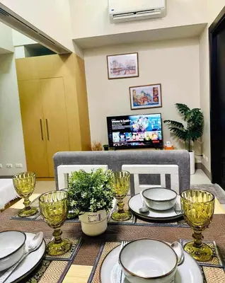 a dining room table with plates and glasses on it at Taguig Parksuit 1BGC in Manila