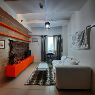 a living room with a couch and a table at Quaint One Br Apartment in Manila