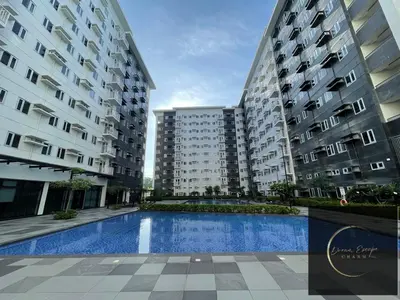 two tall buildings with a swimming pool between them at DreamEscape by Charm Residences in Manila