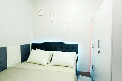 a bed with white pillows in a small room at Sapphira Manor Luxurious Condo by the Bay in Manila