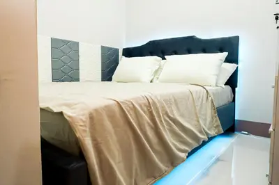 a bedroom with a large bed with white pillows at Sapphira Manor Luxurious Condo by the Bay in Manila