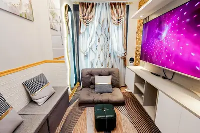 a small living room with a large screen tv at Sapphira Manor Luxurious Condo by the Bay in Manila