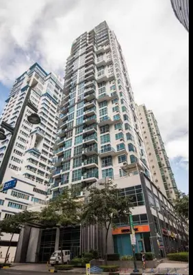 a tall white building with a tree in front of it at QUITE Euro Luxe 3BR 7 mins walk to high street in Manila