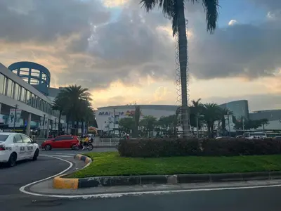a car driving down a street with a palm tree at Gentry Manor Family Suite Balcony City View WiFi Netflix close to Okada 12B in Manila