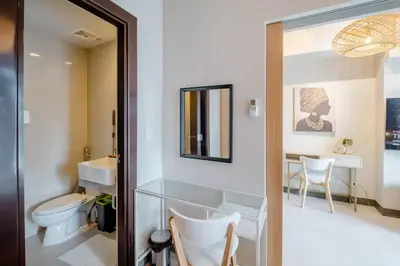 a bathroom with a toilet and a sink and a mirror at Uptown BGC in Manila
