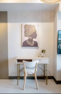 a desk with a chair and a picture on the wall at Uptown BGC in Manila