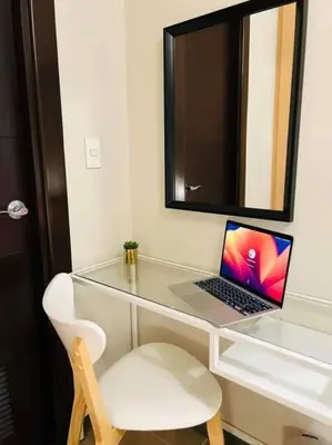 a laptop computer sitting on a glass desk with a chair at Uptown BGC in Manila