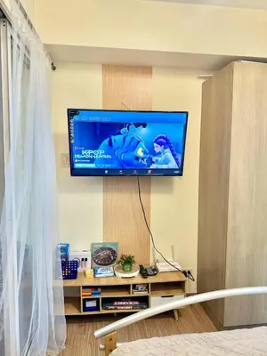 a living room with a flat screen tv on a wall at Aesthetic Beach View Unit in Azure Parañaque in Manila