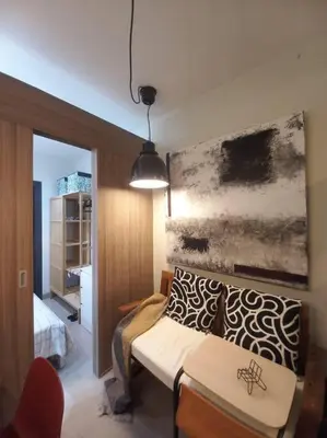 a room with a bed and a couch and a table at Modern Rustic 1-Bed Condo in MoA Complex in Manila