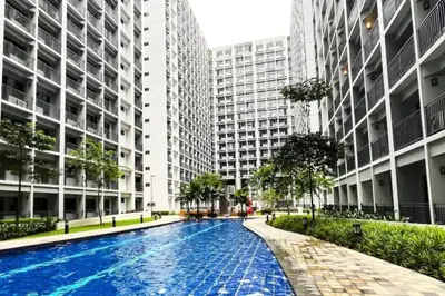 a swimming pool in a city with tall buildings at Modern Rustic 1-Bed Condo in MoA Complex in Manila