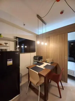 a kitchen with a table and chairs and a refrigerator at Modern Rustic 1-Bed Condo in MoA Complex in Manila