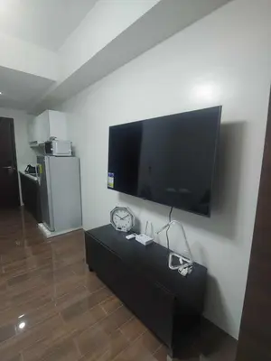 a living room with a large flat screen tv on the wall at 1br at Air Makati Ayala near Makati med in Manila