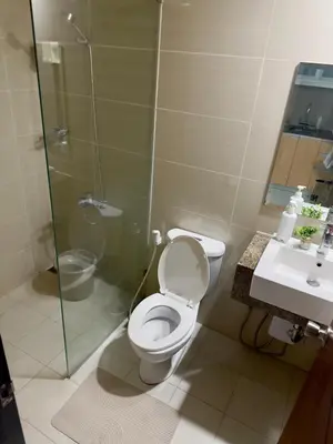 a bathroom with a toilet and a shower and a sink at Cozy 1BR Condo with Uptown Mall View - BGC Zen Suite in Manila