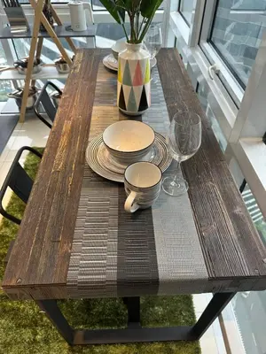 a wooden table with plates and glasses and a vase at Modern Chic 2BR with Panoramic Golf View in BGC in Manila