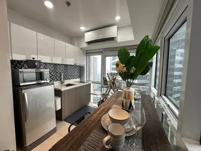 a kitchen with a table with a vase of flowers on it at Modern Chic 2BR with Panoramic Golf View in BGC in Manila