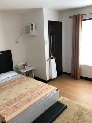 a bedroom with a bed and a window and a fan at Simple Living in Anabu Primero