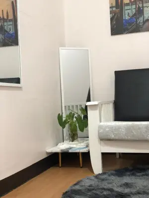 a mirror sitting next to a chair and a plant at Simple Living in Anabu Primero