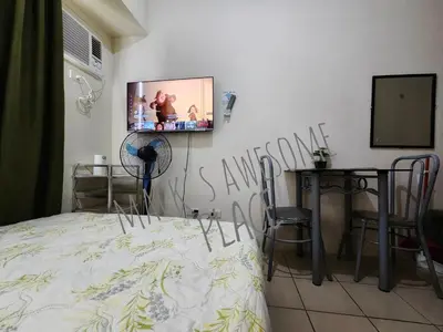 a bedroom with a bed and a tv on the wall at Macks Awesome 12 Place Fast Wifi Netflix in Manila