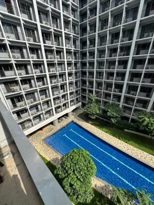 an apartment building with a swimming pool in front of it at Katkat Shore 2 Staycation in Manila