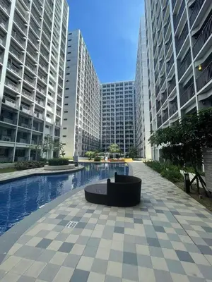a bench in the middle of a city with tall buildings at Shore 2 Residences MOA DMBV in Manila