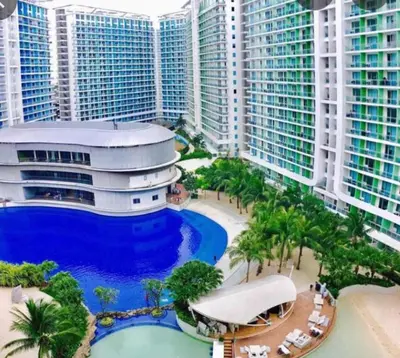 arial view of a building with a pool and palm trees at 2BR Cozy Condo at Azure Urban Resort Residences by Gigi in Manila