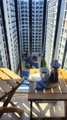 a wooden table with a cup of coffee on a table at The New Villa at Shore 2 Residences in Manila