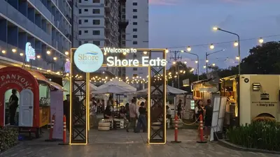a street market with lights and people walking around at The New Villa at Shore 2 Residences in Manila