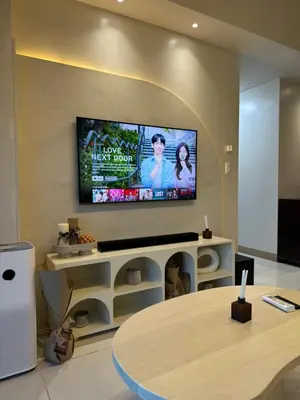 a living room with a tv on a wall at Panoramic Seaview 2BR Near Airport Facing the Bay - 7g in Manila