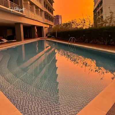 a swimming pool with a reflection of a building at Homefort at Lush Residences Makati in Manila