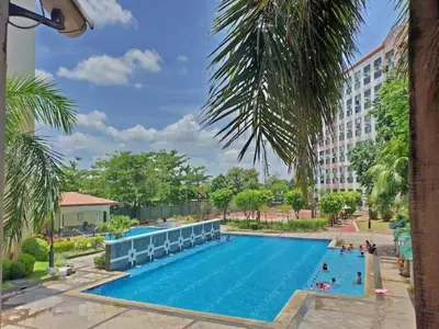 a pool at the resort with people swimming at Fully-furnished 2BR Condo in Pasig, Cainta in Cainta