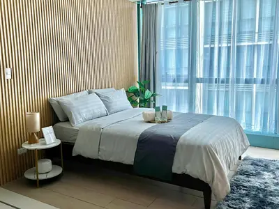 a bedroom with a bed and a large window at Affordable One Bedroom at One Uptown, BGC Manila in Manila