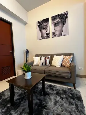 a living room with a couch and a table at Affordable One Bedroom at One Uptown, BGC Manila in Manila