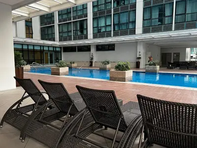 a group of chairs sitting in front of a swimming pool at Affordable One Bedroom at One Uptown, BGC Manila in Manila