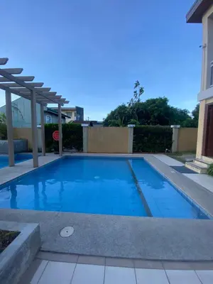 a swimming pool with blue water in a yard at Paradise Room in Las Piñas City in Manila