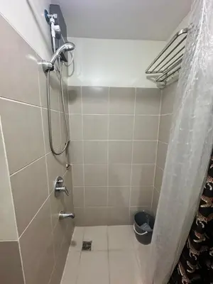 a bathroom with a shower with a toilet in it at Prisma Residences Astra Building in Manila