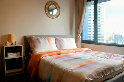 a bedroom with a bed with a window and a mirror at Air Residence 1BR Condo with City View in Manila