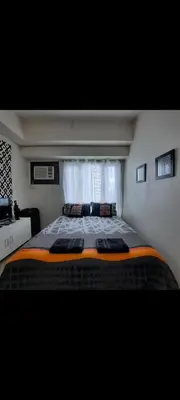 a large bed in a room with a window at THE BEACON Aparthotels in Manila